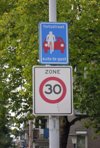 The sign reads "Bike Street. Cars are guests"